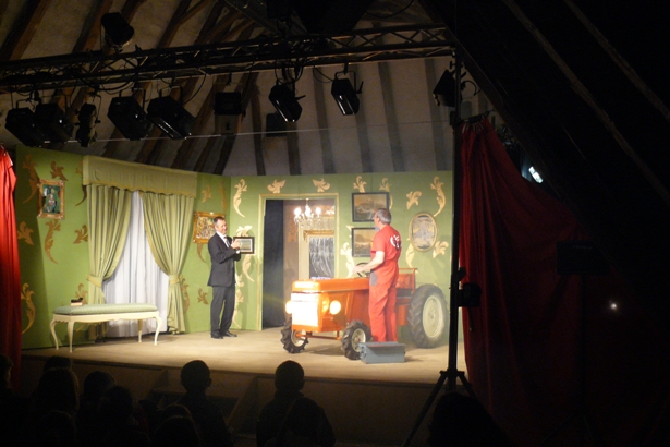 Monsieur Forestier et Mourlon face à face avec un tracteur entre eux dans un salon